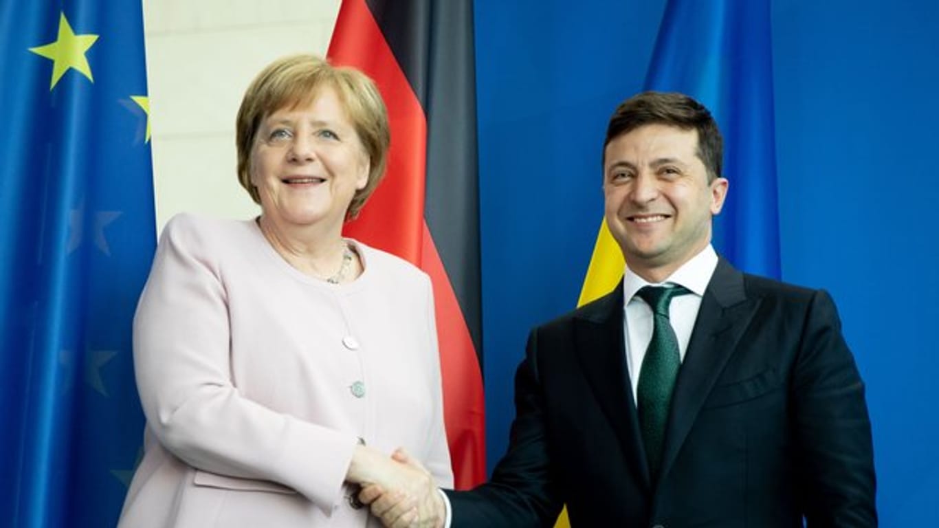Bundeskanzlerin Angela Merkel und der ukrainische Präsident Wolodymyr Selenskyj reichen sich nach einer Pressekonferenz die Hände.