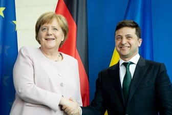 Bundeskanzlerin Angela Merkel und der ukrainische Präsident Wolodymyr Selenskyj reichen sich nach einer Pressekonferenz die Hände.