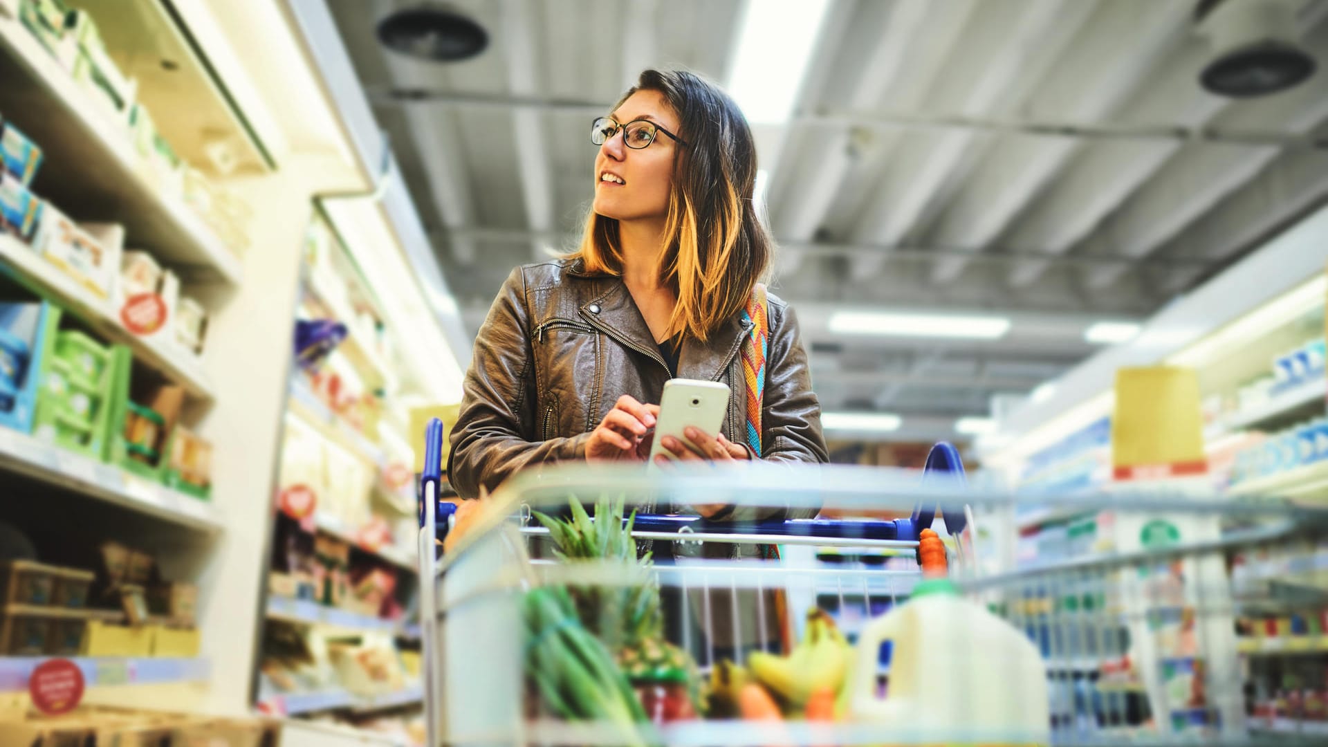 Eine Frau prüft mit ihrem Handy Lebensmittel: Die Ampel der App Grünzeit zeigt an, wann welches regionale Produkt Saison hat.