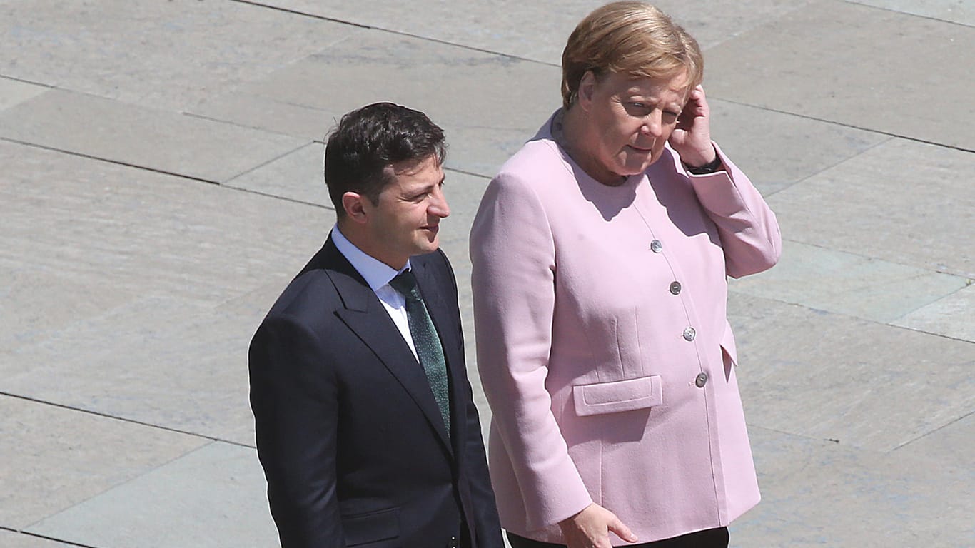 Angela Merkel fasst sich an den Kopf: Bei einem Staatsempfang mit dem ukranischen Präsidenten Selensky fing sie heftig an zuzittern.