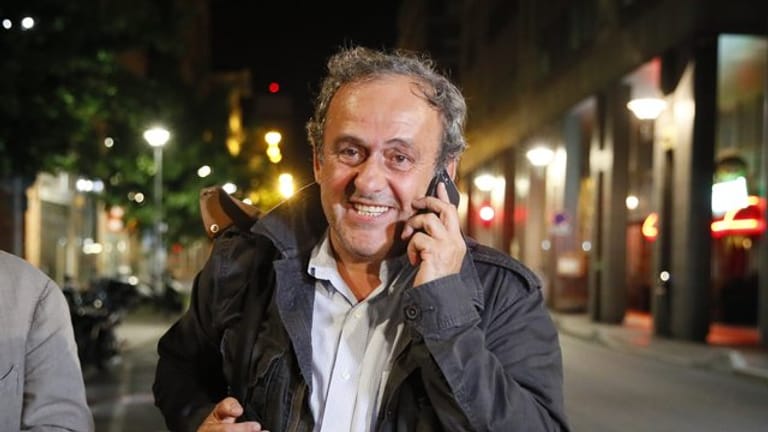 Michel Platini telefoniert nach seiner Entlassung aus dem Gewahrsam der Polizei.