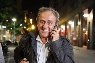 Michel Platini telefoniert nach seiner Entlassung aus dem Gewahrsam der Polizei.