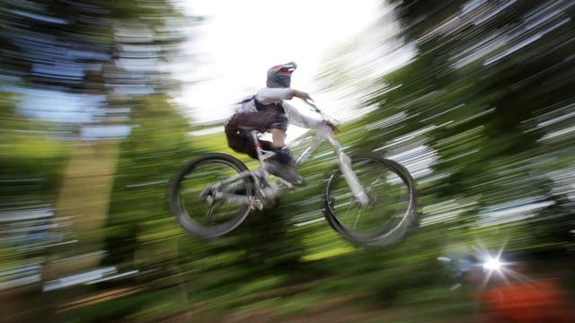 Ein Mountainbiker fährt im Wald: Die Auswahl der Strecken ist so groß, dass jeder die Herausforderung für sein individuelles Können findet.