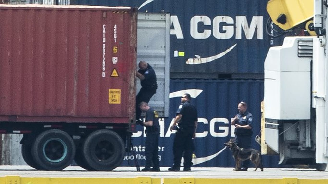 Mit einem Hund inspizieren Polizisten einen Container im Hafen von Philadelphia.