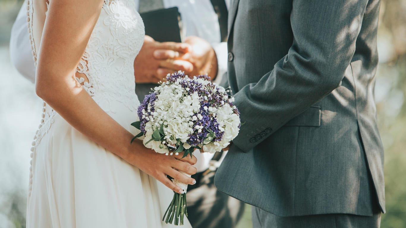 Ein Paar bei der Trauung: Die Hochzeitsfeier sollte gut geplant werden – auch finanziell.