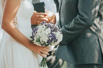 Ein Paar bei der Trauung: Die Hochzeitsfeier sollte gut geplant werden – auch finanziell.