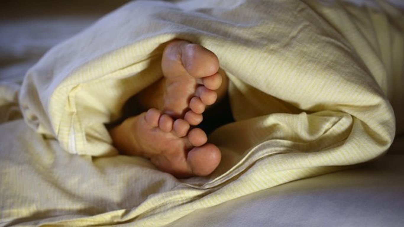 Die Füße einer Frau ragen unter einer Bettdeck hervor (Symbolbild): Es gebe zu wenig Schlaflabore in Deutschland.