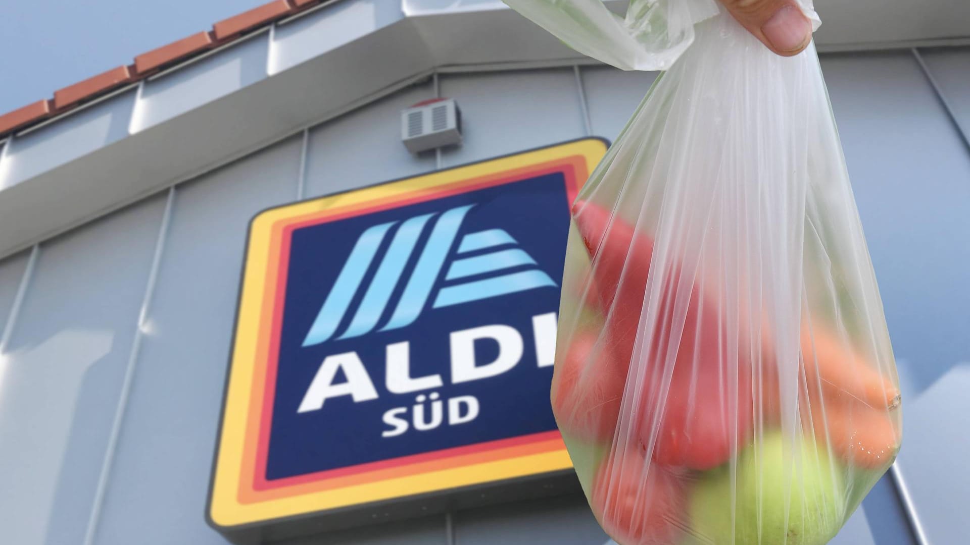 Eine Tüte mit Obst und Gemüse vor einer Aldi-Filiale: Der Discouter bietet einen pauschalen Rabatt auf rund 100 Lebensmittel.