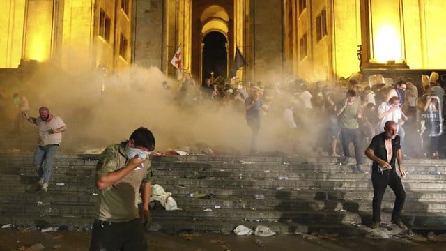 Demonstranten fliehen vor dem georgischen Parlament vor von Polizisten abgefeuertem Tränengas. Demonstranten fliehen vor dem georgischen Parlament vor von Polizisten abgefeuertem Tränengas.
