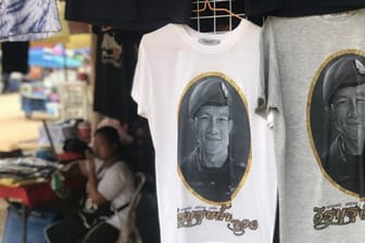 Vor der Tham-Luang-Höhle im äußersten Norden Thailands werden T-Shirts verkauft, auch mit dem Porträt des Ex-Marinetauchers Saman Kunan.