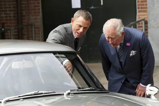 Daniel Craig (l) zeigt Prinz Charles (r) den Aston Martin DB5.