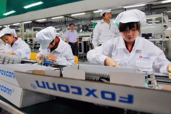 Chinesische Mitarbeiter des Apple-Zulieferers Foxconn arbeiten am Fließband: Apple und Microsoft wollen ihre in China gefertigten Produkte vor einer neuen Runde geplanter US-Zölle schützen.