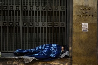 Ein Obdachloser hat sich vor der Bank von Griechenland in Athen zum Schlafen gelegt.
