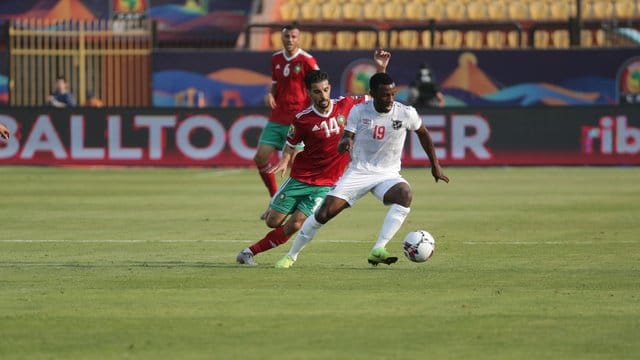 Marokkos Mbark Boussoufa (R) und Namibias Petrus Shitembi (l) kämpfen um den Ball. Marokkos Mbark Boussoufa (R) und Namibias Petrus Shitembi (l) kämpfen um den Ball.