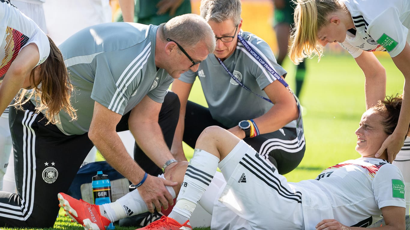 Betreuer kümmern sich um die am Knie getroffene Lina Magull.