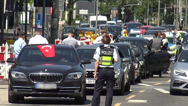 Eine Polizistin steht vor den Fahrzeugen eines türkischen Hochzeutskorsos. Eine Polizistin steht vor den Fahrzeugen eines türkischen Hochzeutskorsos.