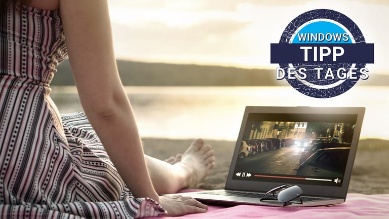 Eine Frau am Strand schaut Video-Streaming auf dem Laptop: Immer mehr Windows 10-Rechner unterstützen Streaming in HDR-Qualität.