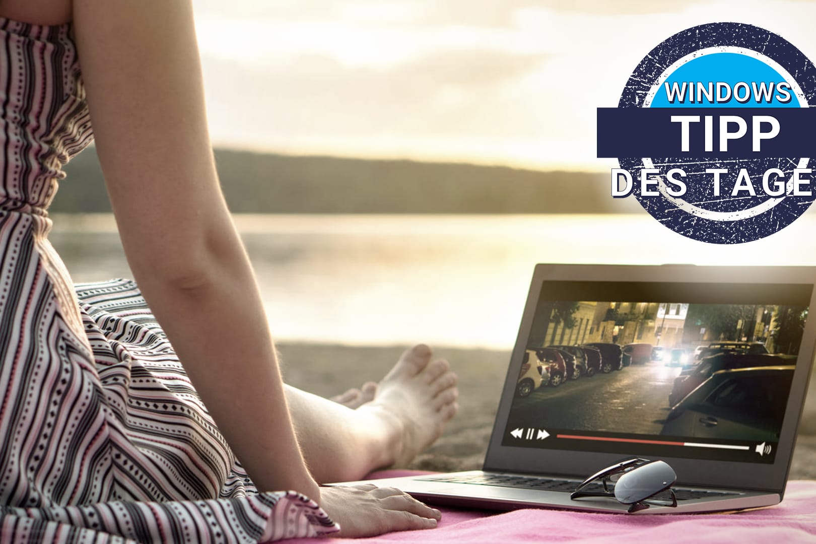 Eine Frau am Strand schaut Video-Streaming auf dem Laptop: Immer mehr Windows 10-Rechner unterstützen Streaming in HDR-Qualität.