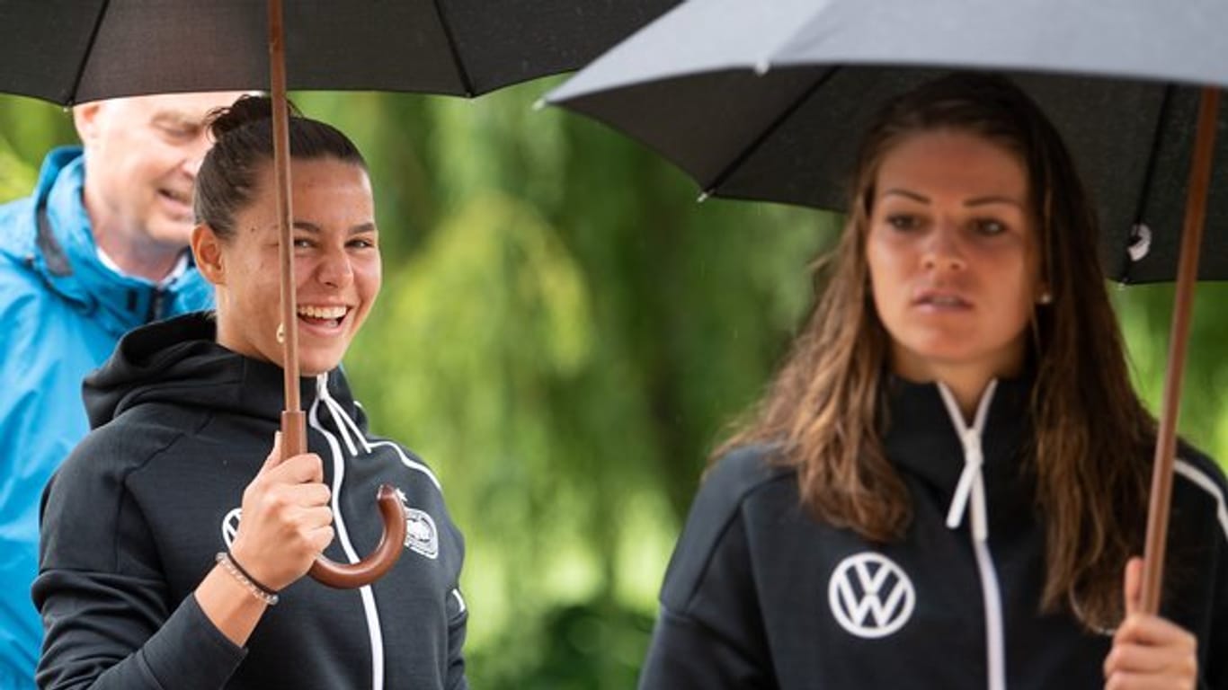 Lena Oberdorf (l) und Melanie Leupolz (r) kommen mit Regenschirm zur Pressekonferenz.