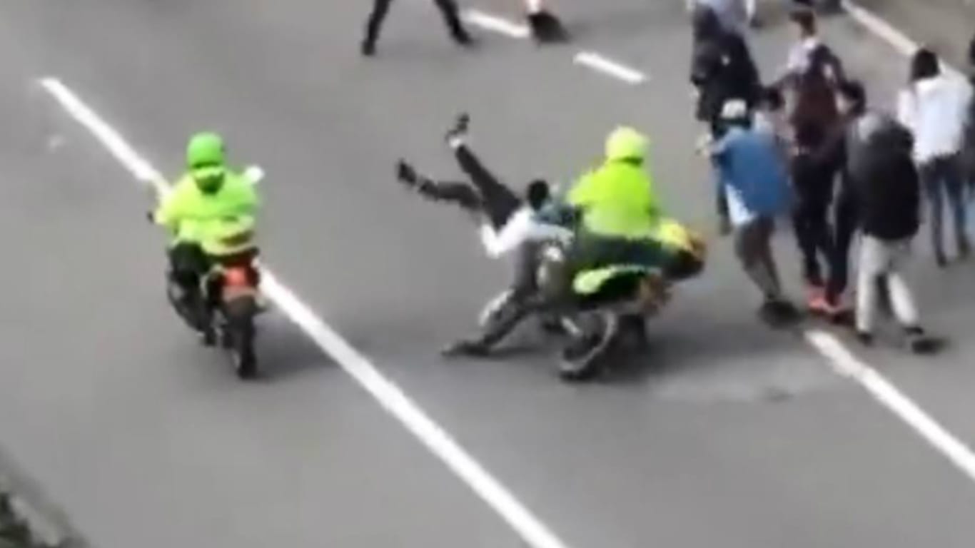 Erschütternde Szene in Bogota: Der Motorradpilot der Polizei fährt einen vor ihm laufenden Skater um.