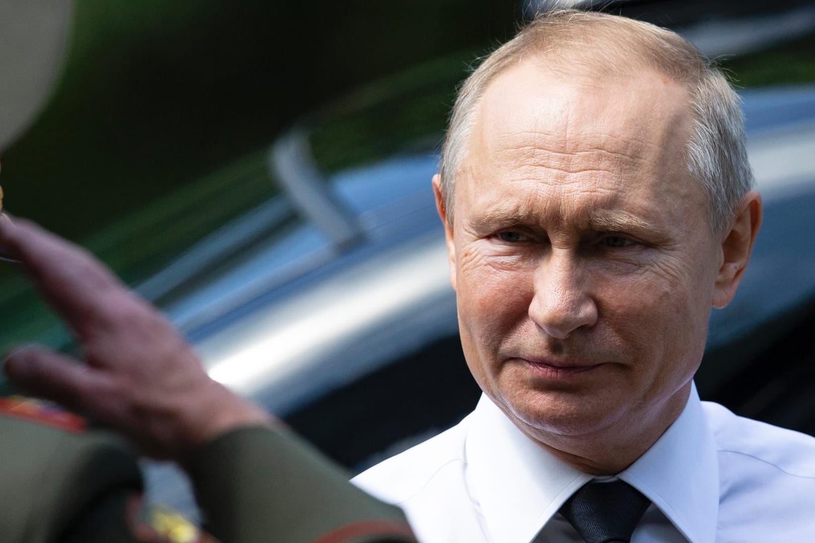 Wladimir Putin wird von einem Offizier bei einer Kranzniederlegung in Moskau begrüßt.