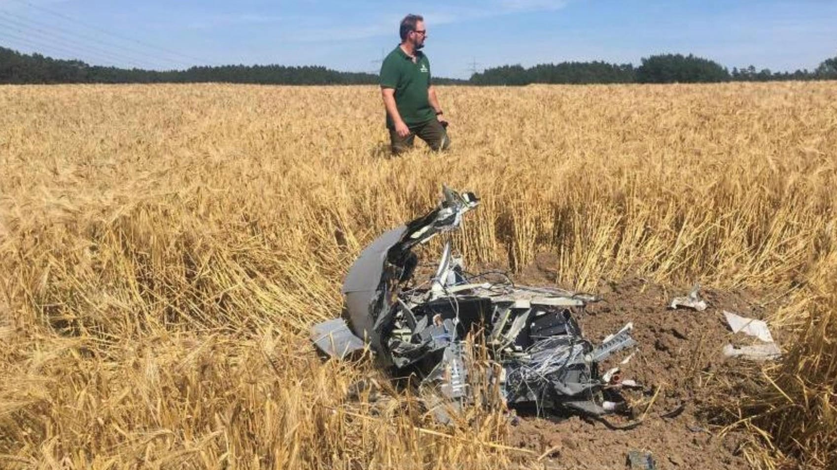 Ein Forstarbeiter steht neben Wrackteilen auf einem Feld nahe der Ortschaft Jabel in Mecklenburg-Vorpommern.