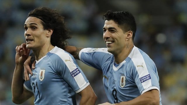 Uruguay-Siegtorschütze Edinson Cavani (l) lässt sich von Luis Suarez feiern.