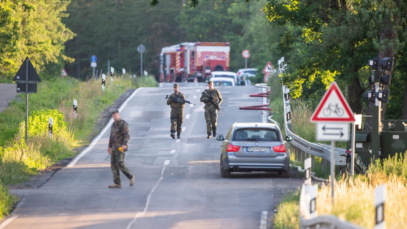Soldaten gehen in der Nähe einer der Absturzstellen eines Eurofighters auf einer Straße: 300 Soldaten suchen an der Mecklenburgischen Seenplatte nach Trümmern.