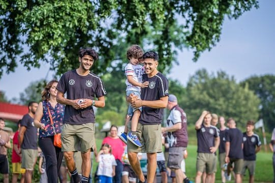 Mahmoud Dahoud (l) und Nadiem Amiri mit einer Gruppe krebskranker Kinder im DFB-Teamhotel in Fagagna.