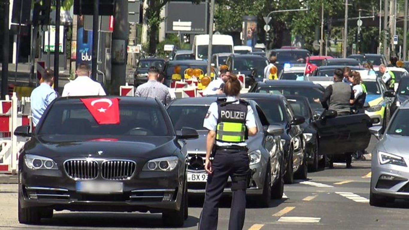 Eine Polizistin steht in Köln vor einem türkischen Hochzeitskorso - einer von dreien, den die Polizei in der Rheinmetropole am Wochenende angehalten hat.