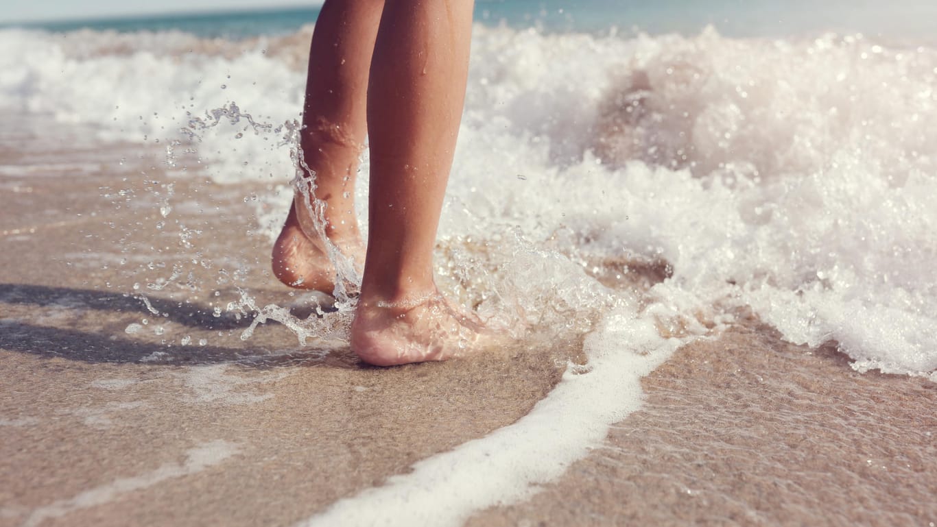 Füße im Meer: Im Badeurlaub spielt die Wassertemperatur eine wichtige Rolle.