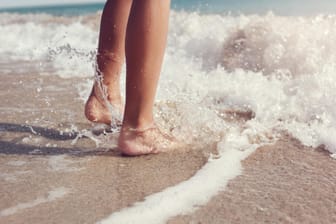 Füße im Meer: Im Badeurlaub spielt die Wassertemperatur eine wichtige Rolle.
