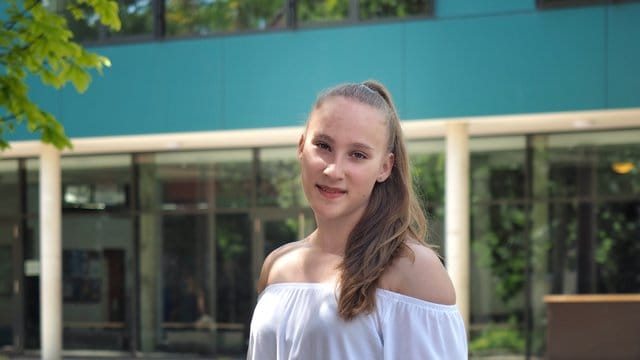 Niedersachsens jüngste Abiturientin Mandy Hoffmann steht mit Blumen in der Hand vor ihrer Schule. Niedersachsens jüngste Abiturientin Mandy Hoffmann steht mit Blumen in der Hand vor ihrer Schule.