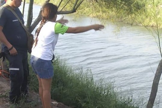 Die Ehefrau zeigt einem mexikanischen Beamten die Stelle, wo ihr Mann und ihre fast zweijährige Tochter beim Überqueren des Rio Grande verschwunden sind.