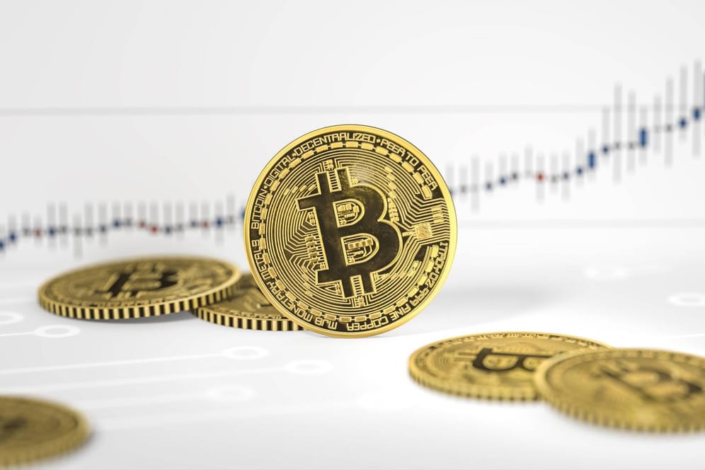 Bitcoin-Münzen vor einem Kurs-Chart (Symbolbild): Seit Jahresbeginn belaufen sich die Kursgewinne auf rund 250 Prozent.