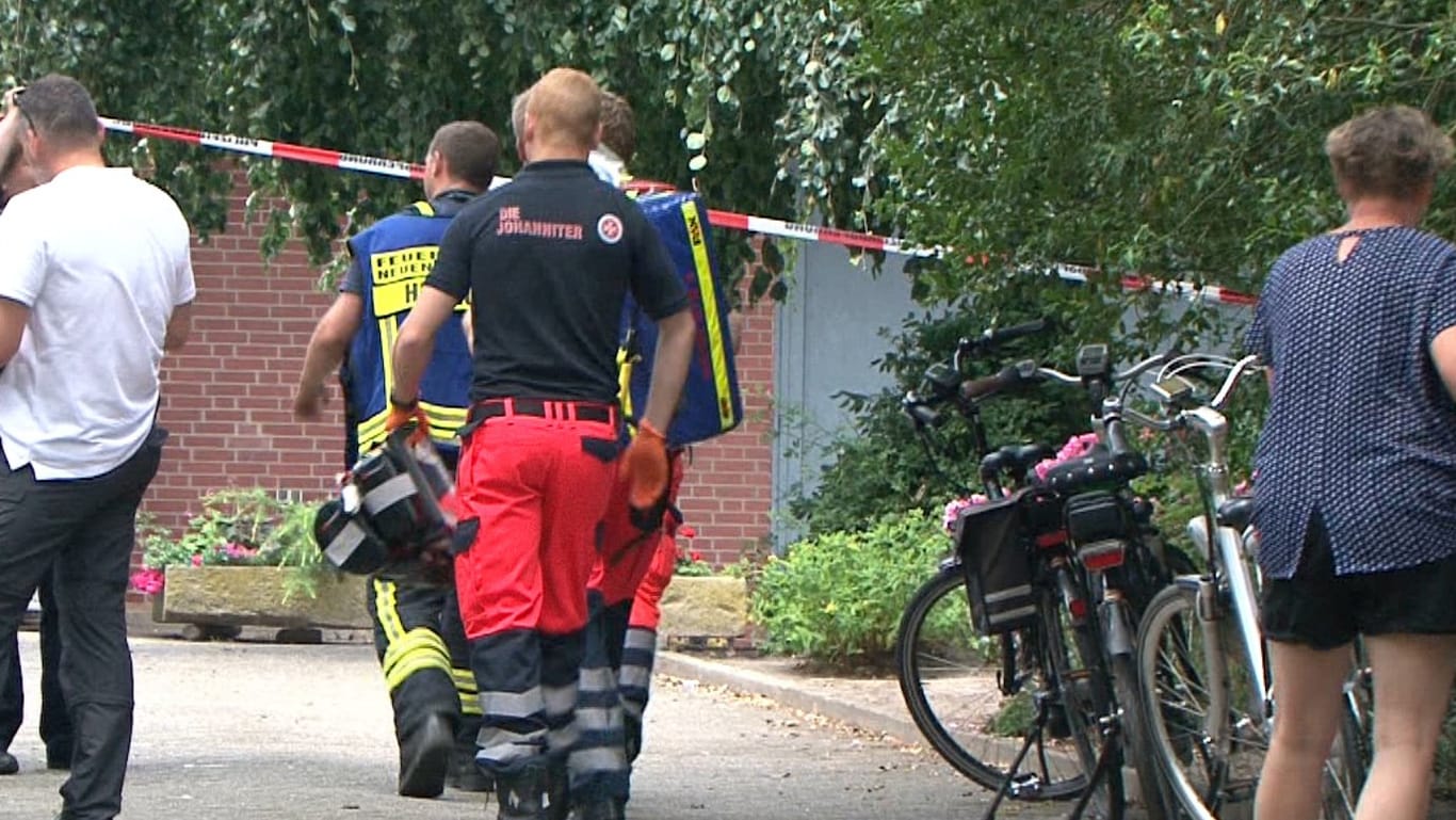 Rettungskräfte betreten ein Grundstück in Neuenkirchen: In einem Brunnenschacht im nördlichen Münsterland ist eine Frauenleiche entdeckt worden.