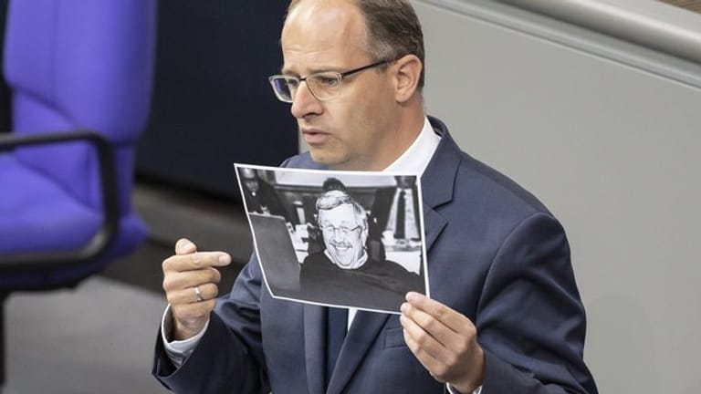 Michael Brand (CDU) hält bei seiner Rede im Bundestag ein Bild des ermordeten Kasseler Regierungspräsidenten Walter Lübcke.