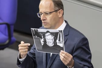 Michael Brand (CDU) hält bei seiner Rede im Bundestag ein Bild des ermordeten Kasseler Regierungspräsidenten Walter Lübcke.
