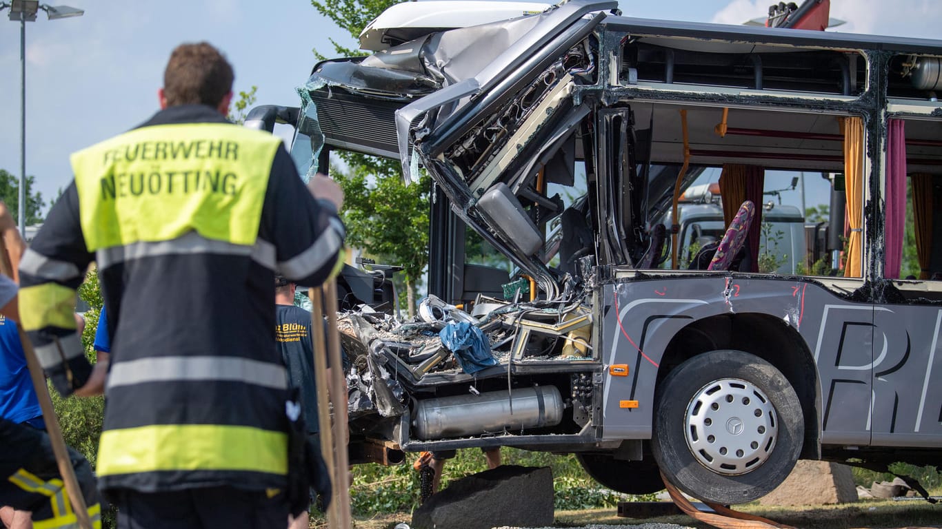 Ein Feuerwehrmann vor dem völlig zerstörten Schulbus: Im bayerischen Neuötting sind 27 Menschen verletzt worden.
