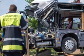 Ein Feuerwehrmann vor dem völlig zerstörten Schulbus: Im bayerischen Neuötting sind 27 Menschen verletzt worden.