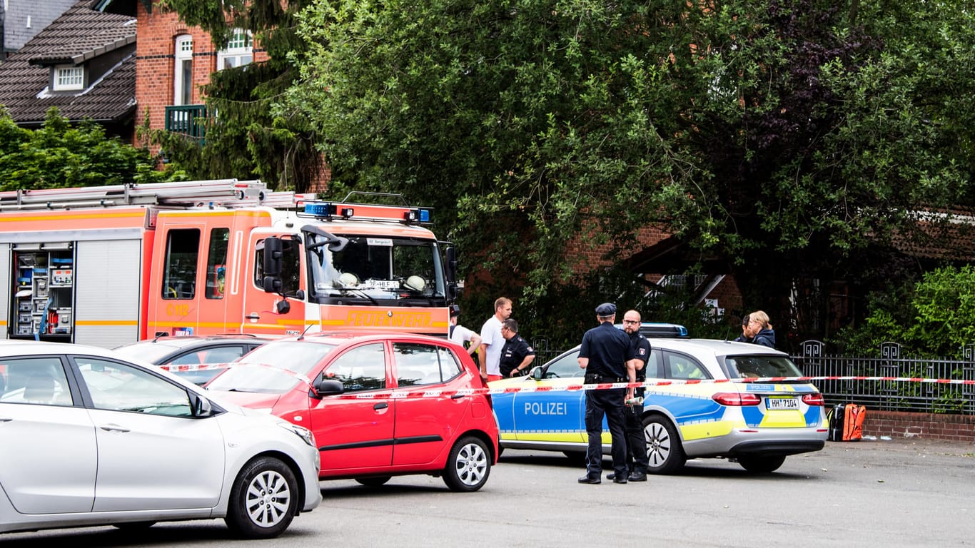 Polizisten und Feuerwehrleute nach der Tat an einer abgesperrten Straße: In Hamburg ist ein Mann im Stadtteil Lohbrügge erschossen worden.