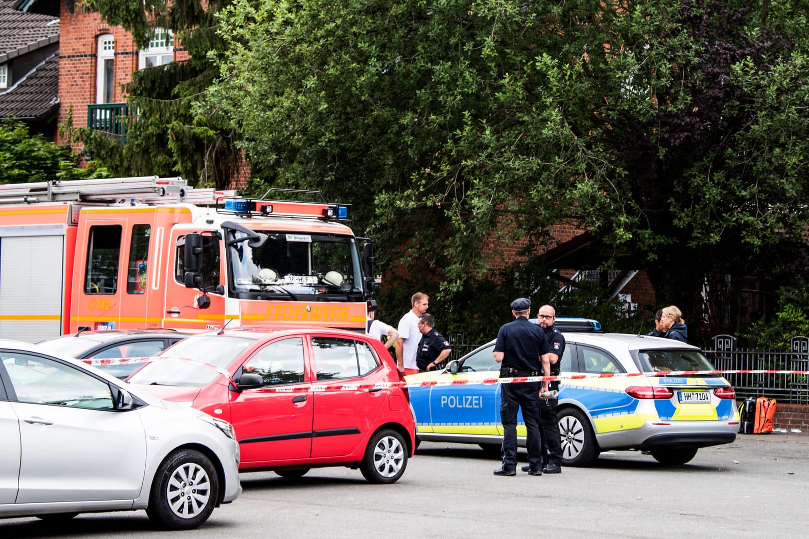 Polizisten und Feuerwehrleute nach der Tat an einer abgesperrten Straße: In Hamburg ist ein Mann im Stadtteil Lohbrügge erschossen worden.