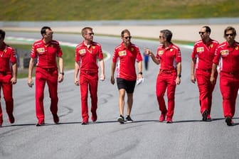 Sebastian Vettel (M) geht mit seinem Team die Rennstrecke in Spielberg ab.