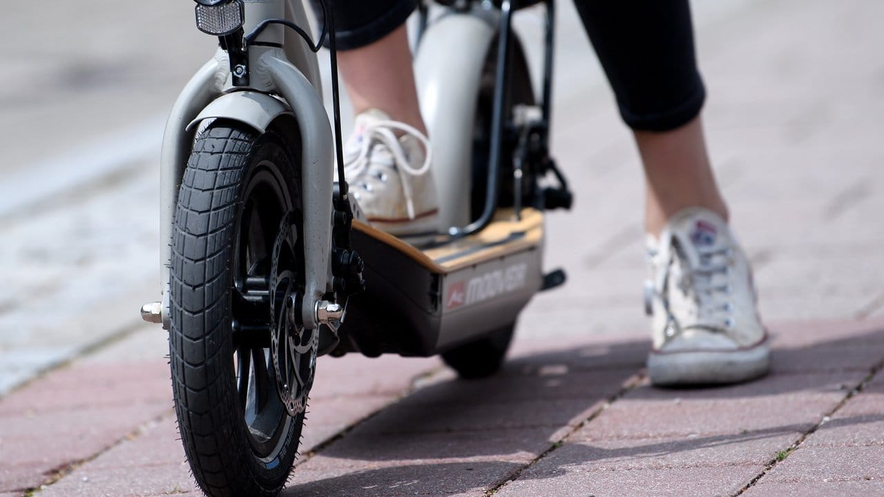 Eine Frau macht auf einem E-Scooter "Metz Moover" vor dem Geschäft von efuture eine Probefahrt.