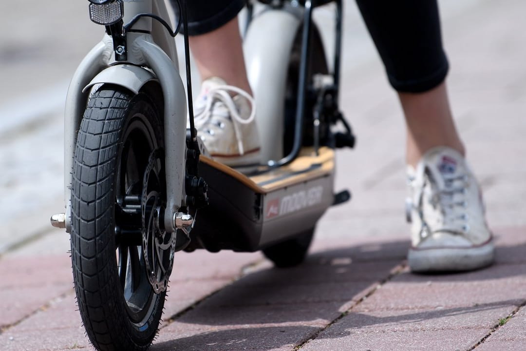 Eine Frau macht auf einem E-Scooter "Metz Moover" vor dem Geschäft von efuture eine Probefahrt.