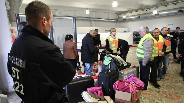 Polizisten begleiten abgelehnte Asylbewerber zu einem Terminal.