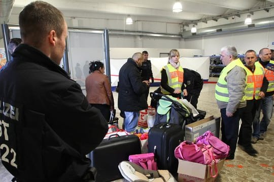 Polizisten begleiten abgelehnte Asylbewerber zu einem Terminal.