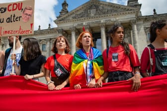 Fridays for Future in Berlin: Junge Menschen halten im Rahmen der Demonstration einen roten Stoff als Symbol des ökologischen Notstandes vor dem Bundestag.