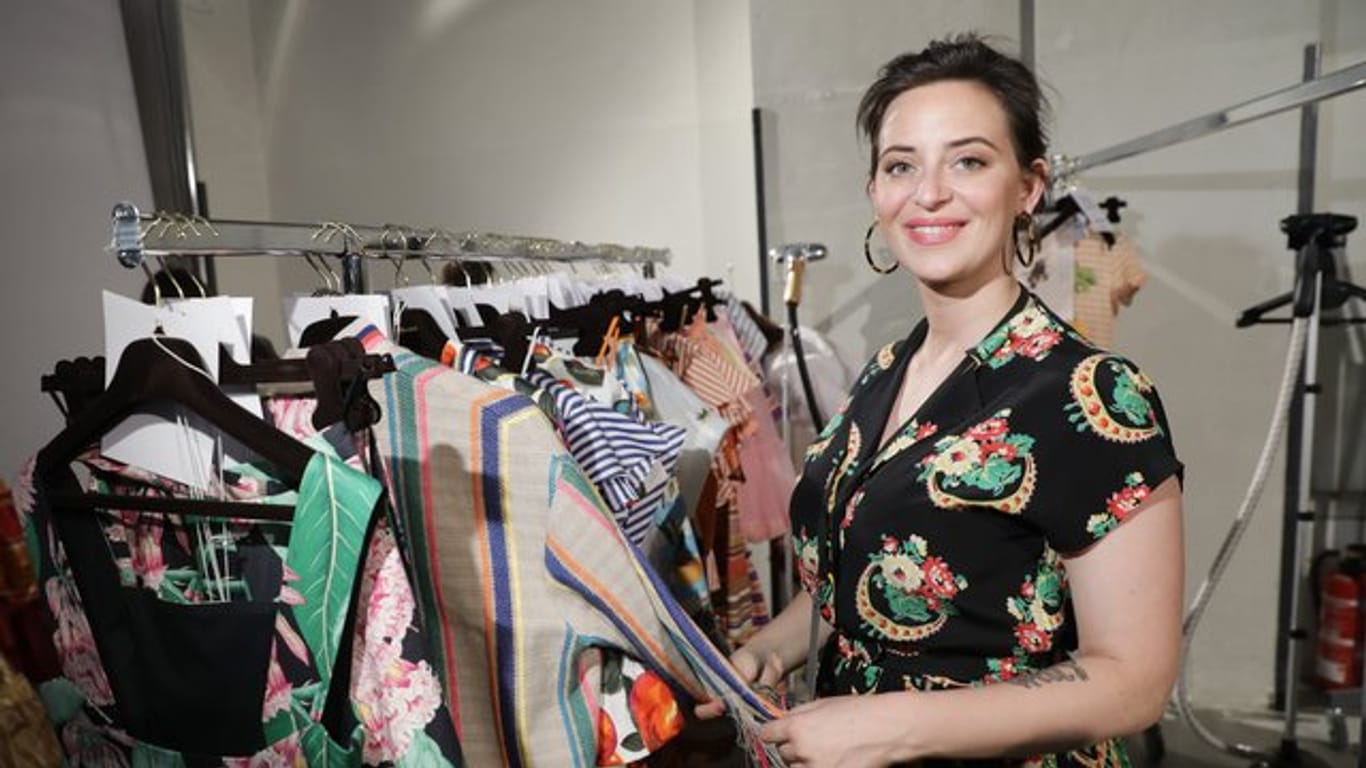 Designerin Lena Hoschek neben ihren Kleidern auf der Fashion Week 2018.