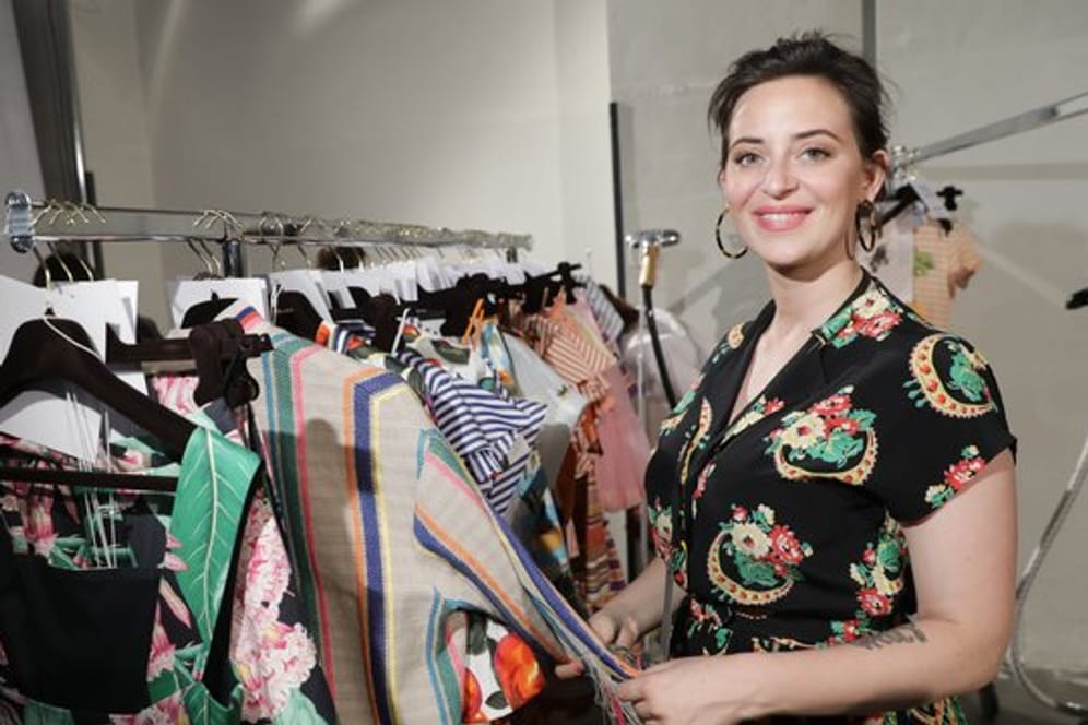Designerin Lena Hoschek neben ihren Kleidern auf der Fashion Week 2018.